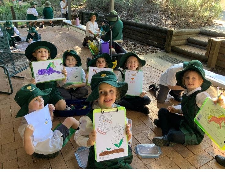 Students showing their drawings at the wellbeing wagon