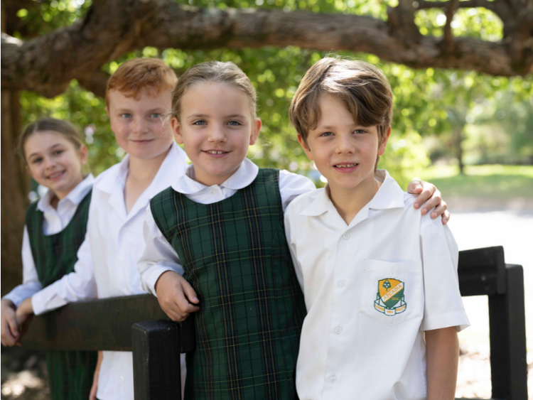 A group of students in formal winter uniform smiling at the camera